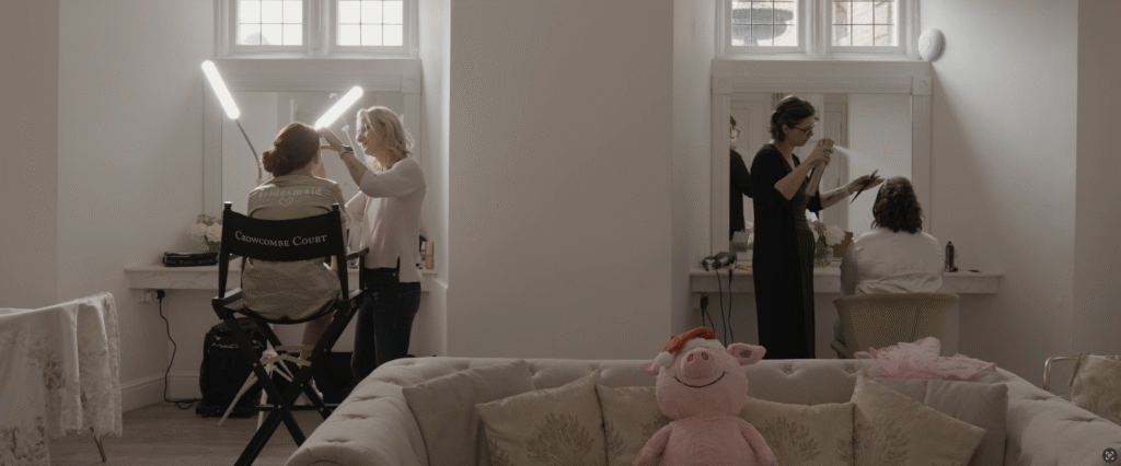 Make-up atist and hair stylist at Crowcombe Court, Somerset tend to bride and bridemaid in the getting ready room