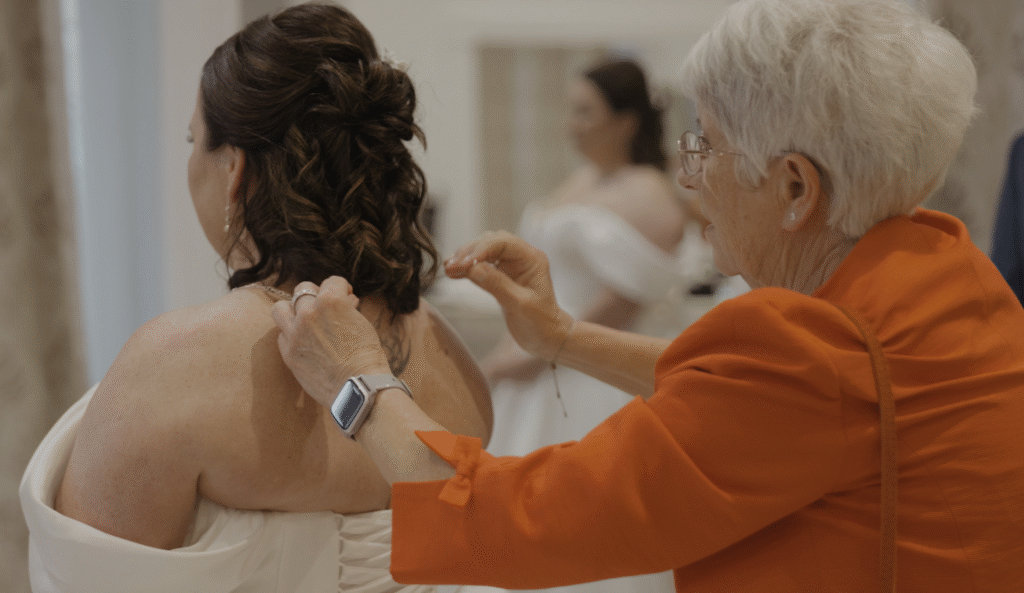 Ria's Mum doing up her necklace as she gets ready to be married at Crowcombe Court