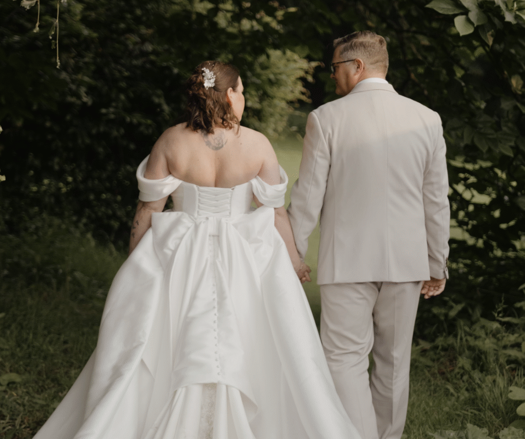 Rich and Ria from behind sharing a gaze as they stroll through the grounds of Crowcombe Court, Somerset